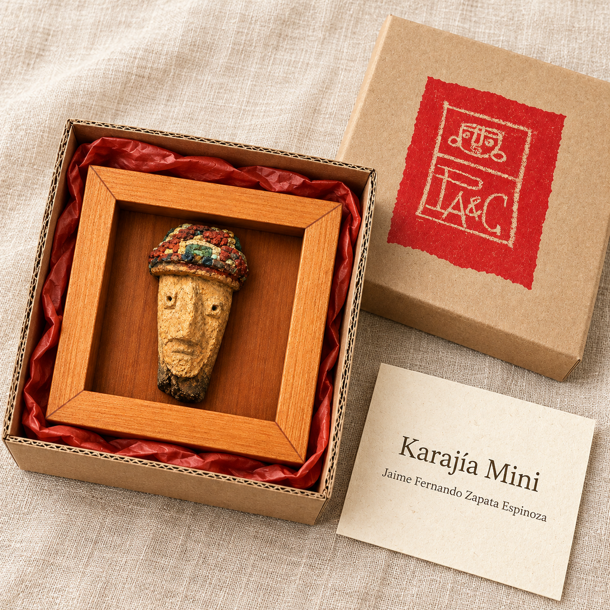 Karajía Mini en caja de cartón microcorrugado con etiqueta PA&C y tarjeta específica de la obra; recreación digital de su presentación.