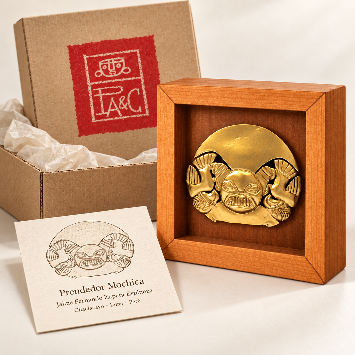 Prendedor Mochica · Shadow Box 13 cm junto a caja de cartón PA&C y tarjeta de la obra: recreación digital de presentación.