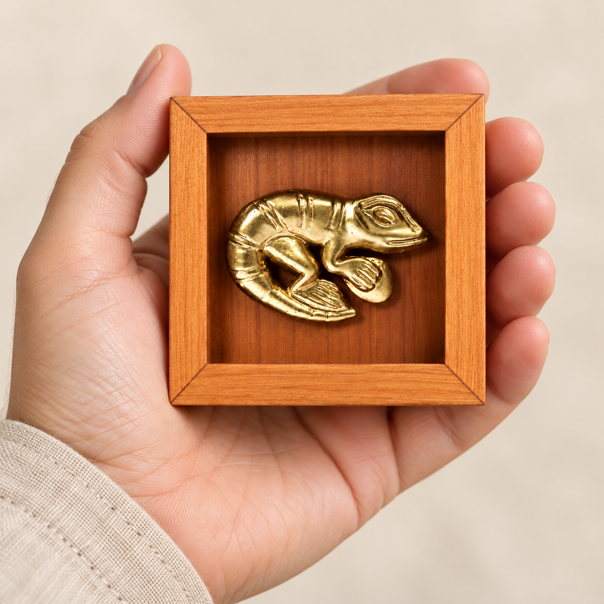 Lagarto Mochica Mini de 7 × 7 cm sostenido en una mano; representación digital de escala aproximada.