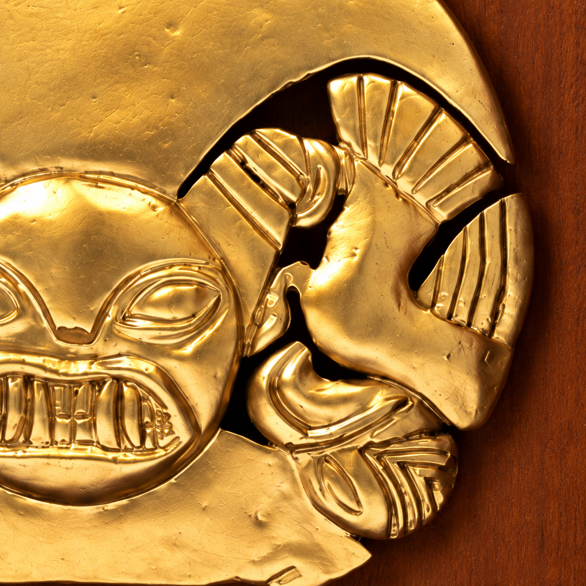 Prendedor Mochica · Shadow Box 13 cm: macro digital de los motivos laterales, las incisiones y los espacios calados del relieve.
